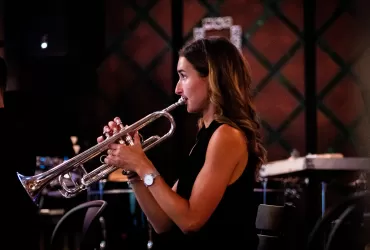 A young woman playing a trumpet